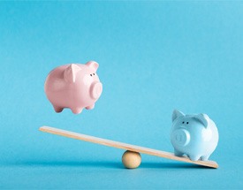 Piggy banks on balance scale 