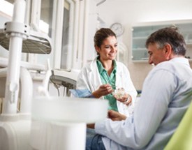 Denture dentist smiling at patient during consultation