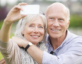 Older couple taking a picture while wearing dentures in Canton