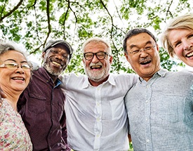 Patient with dentures in Canton smiling with friends