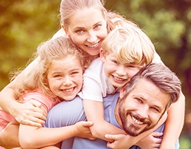 Family of four smiling outdoors