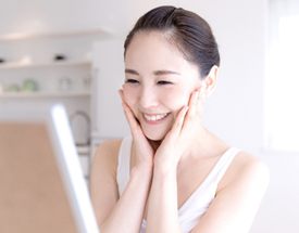 woman smiling looking into mirror