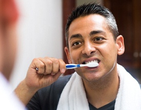 Man brushing his dental implants in Canton