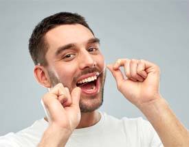 Man flossing after dental implant surgery in Canton