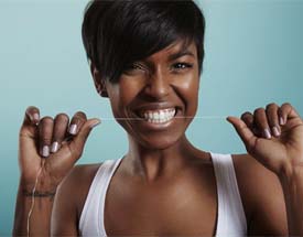 Woman flossing after dental implant surgery in Canton