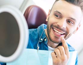 man admiring his smile after dental implant surgery in Canton