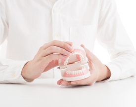 man holding denture model