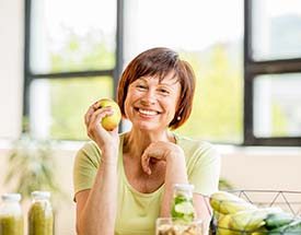 smiling woman holding an apple 