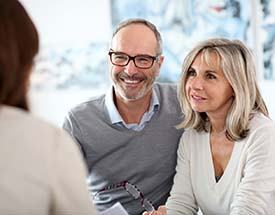 senior man and woman at a dental implant consultation 