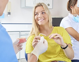Dentist showing Invisalign aligner to patient