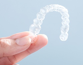 Hand holding invisalign tray