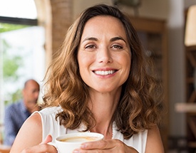 Woman smiling holding coffee