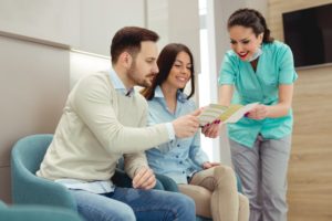 dental team member going over a couple’s dental insurance with them 