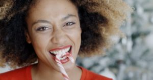 woman biting into candy cane 