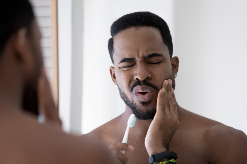 Man holding his jaw due to pain after a root canal