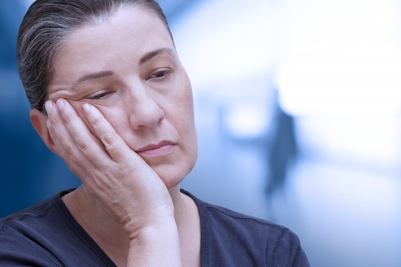 Patient holding their jaw because of dental emergencies