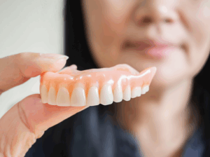 Woman holding dentures