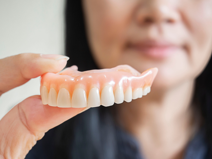 Woman holding dentures